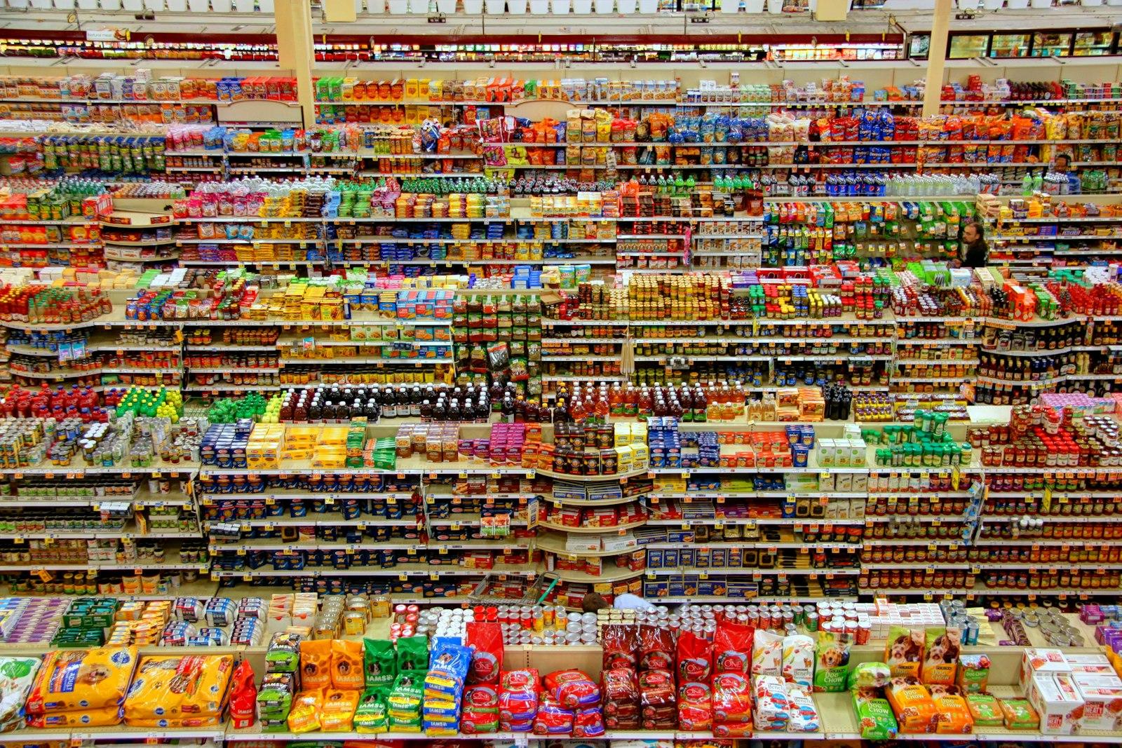 Densely stocked grocery and snack shelving seen from above