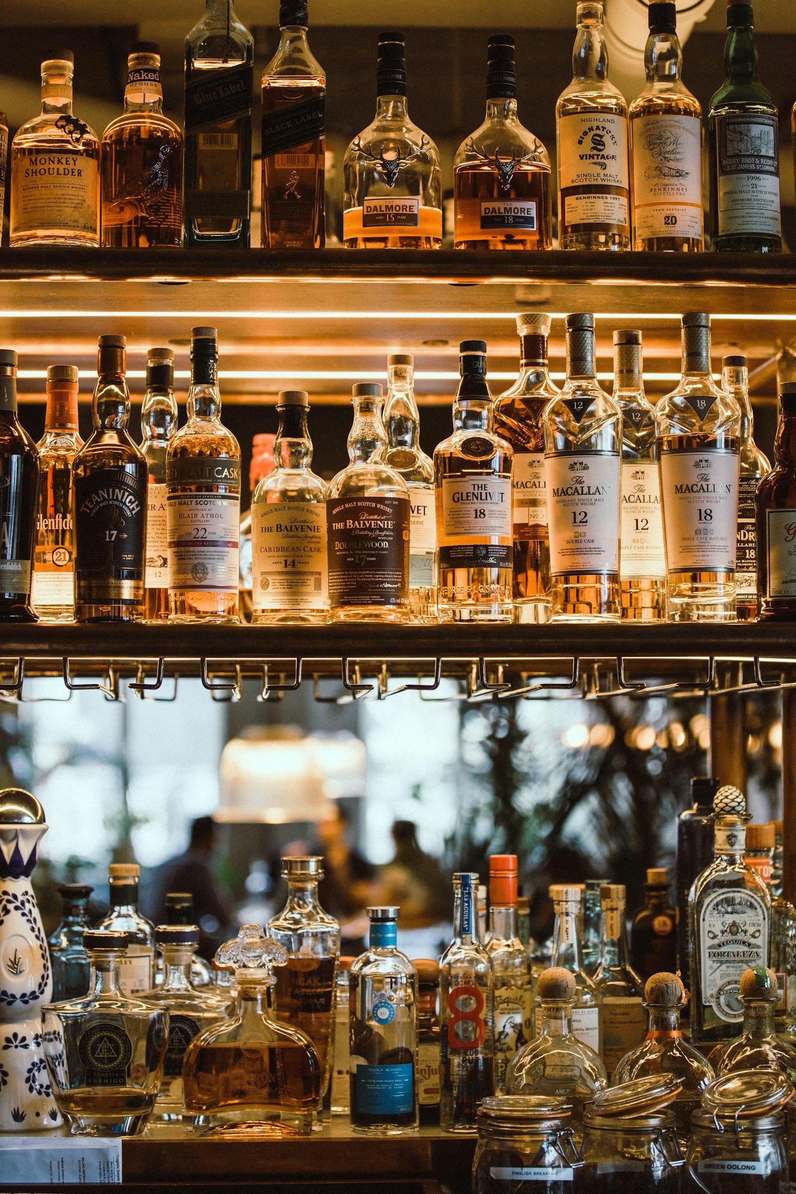 Lit shelves of whisky and other spirits bottles