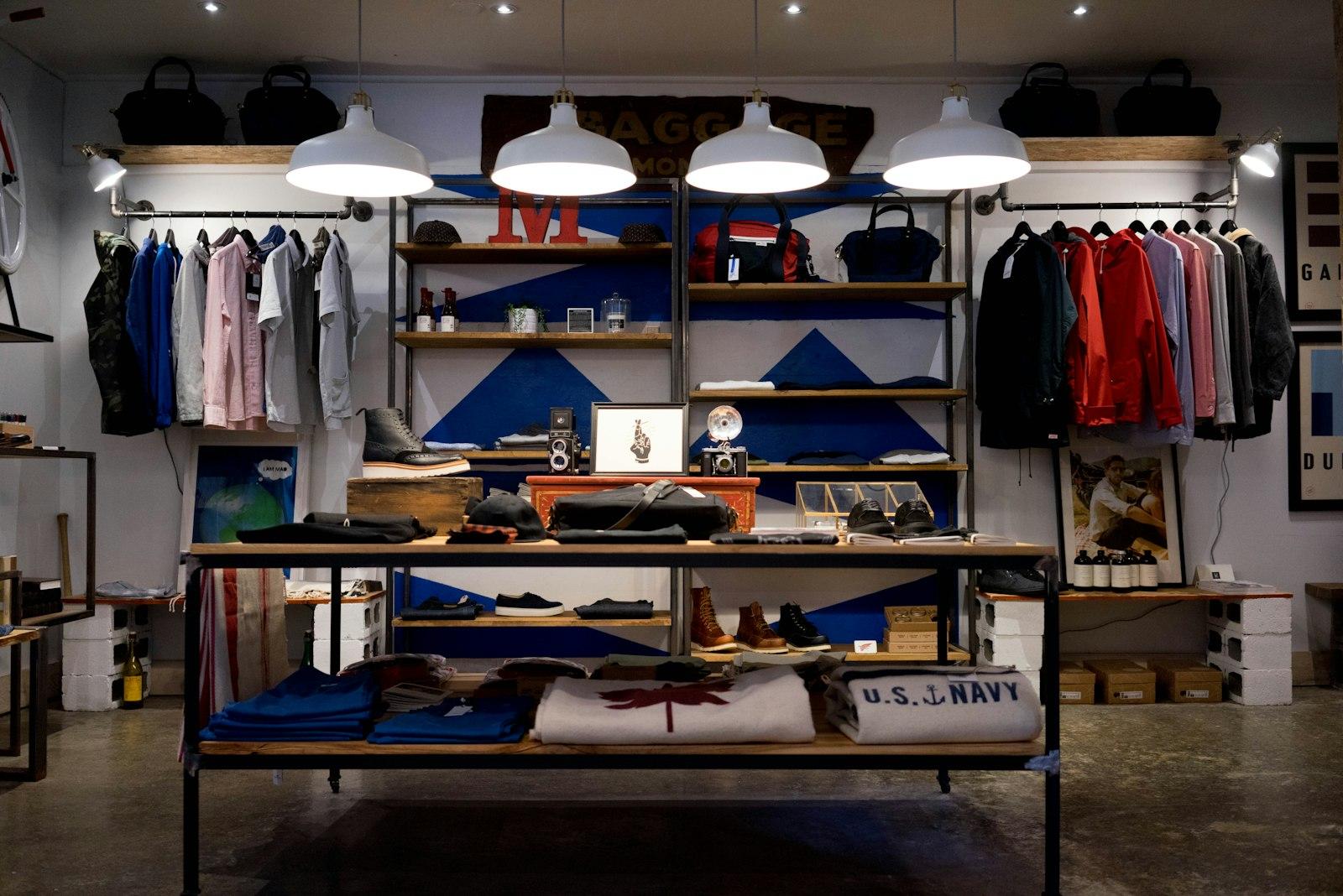 Shop interior with clothing rails, shelving and folded stock on a display table