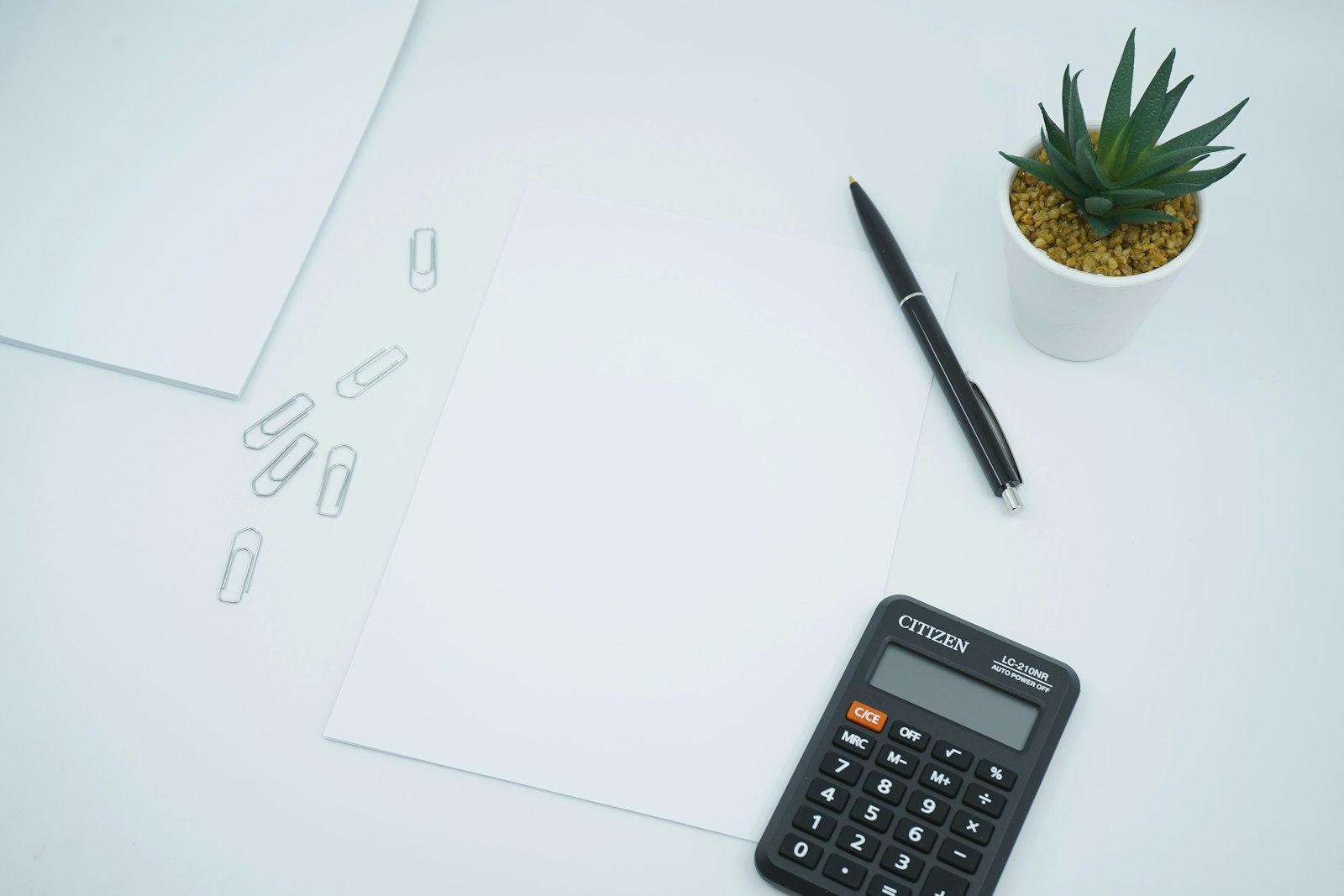 Calculator, pen and paperwork on a desk ready for a stock valuation